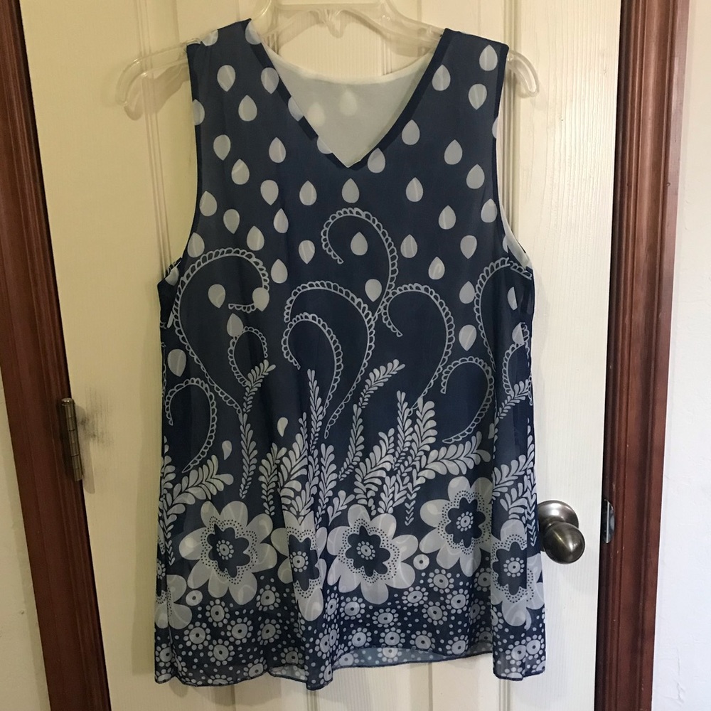 Blue and white floral print sleeveless top with flowy hem.
